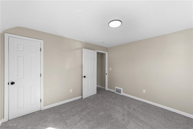 unfurnished bedroom with carpet flooring, baseboards, and visible vents