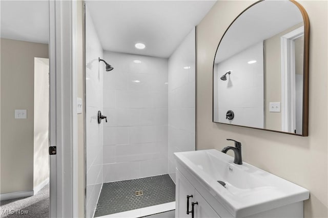 bathroom featuring baseboards, a stall shower, and vanity