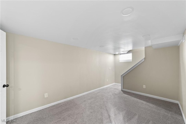 below grade area featuring carpet flooring and baseboards