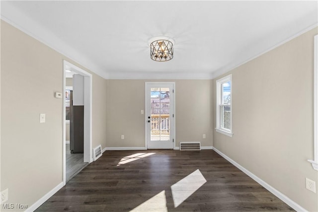 interior space with visible vents, baseboards, wood finished floors, and crown molding