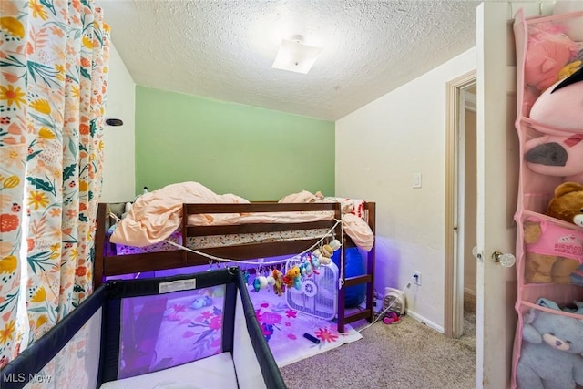 bedroom with baseboards, carpet floors, and a textured ceiling