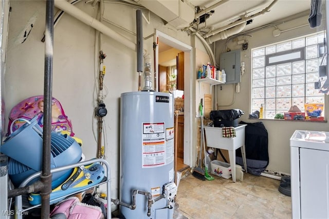 utility room featuring electric panel, gas water heater, and washer / clothes dryer