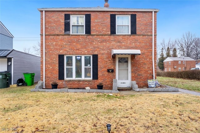 traditional-style house featuring brick siding and a front lawn