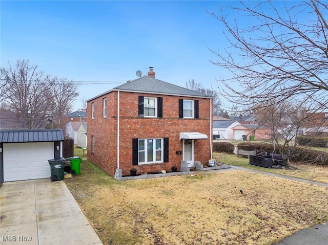 view of front of property with concrete driveway, a front yard, an outdoor structure, brick siding, and a chimney