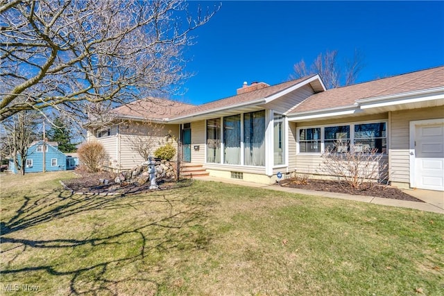 single story home featuring an attached garage, a chimney, and a front lawn