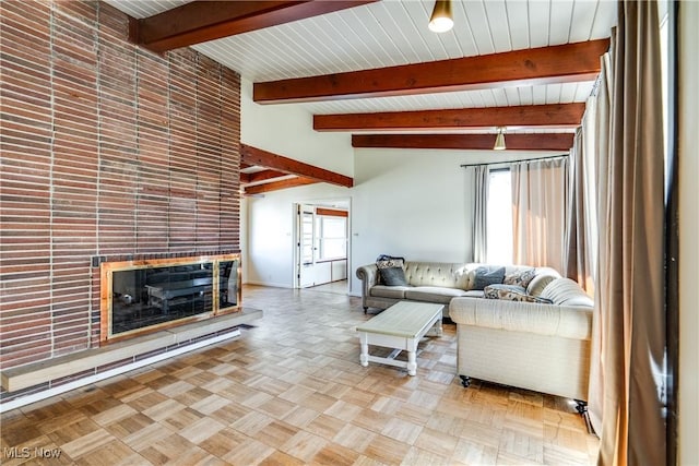 living area with beam ceiling and a tiled fireplace