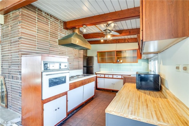 kitchen featuring oven, open shelves, freestanding refrigerator, ventilation hood, and tile patterned flooring