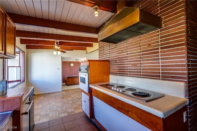 kitchen with brown cabinets, a ceiling fan, ventilation hood, stainless steel electric stovetop, and white oven