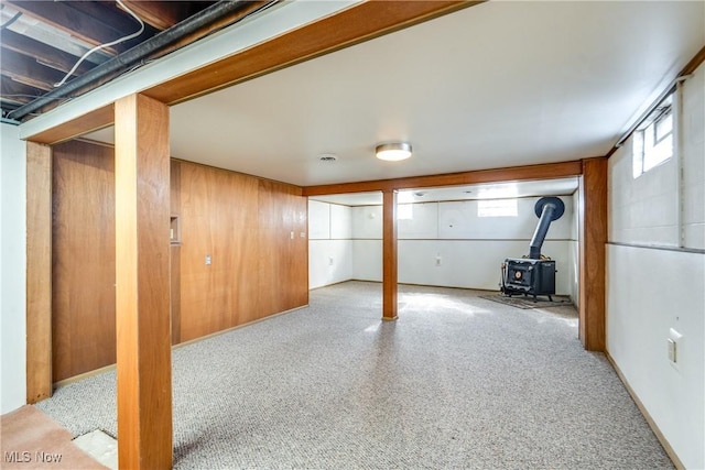 below grade area with wooden walls and a wood stove