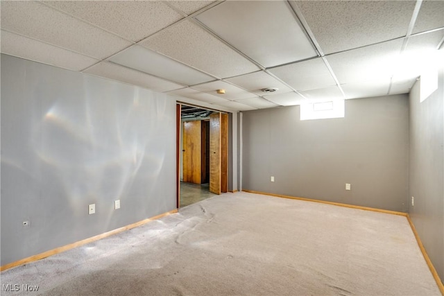 interior space with carpet flooring, baseboards, and a drop ceiling