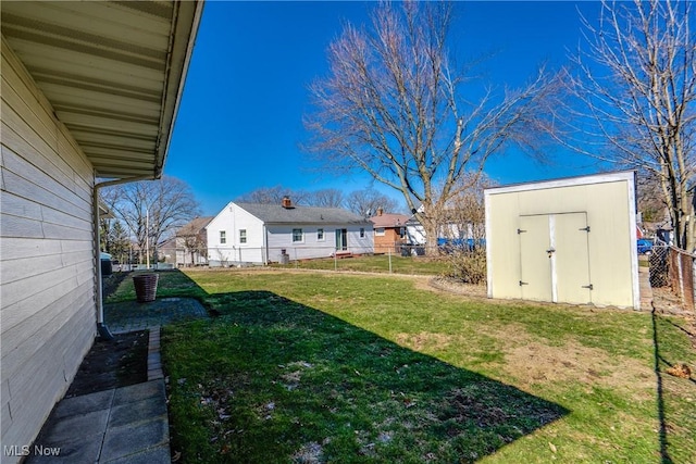 view of yard with a storage unit, an outbuilding, and fence private yard