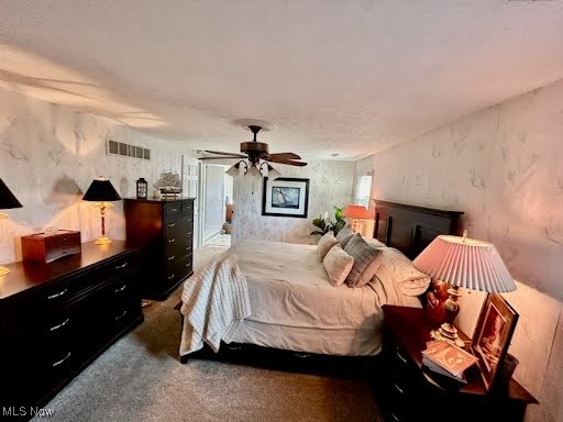 carpeted bedroom with visible vents, access to exterior, and a ceiling fan