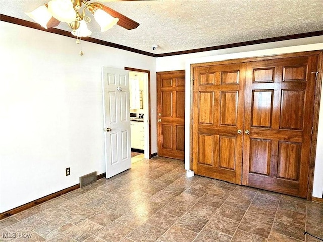 unfurnished bedroom with crown molding, baseboards, visible vents, and a textured ceiling