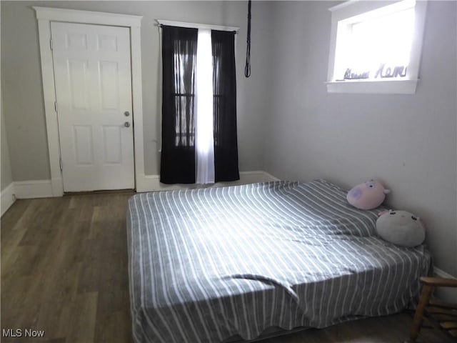 bedroom with baseboards and wood finished floors