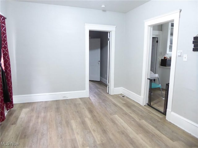 empty room with baseboards and wood finished floors