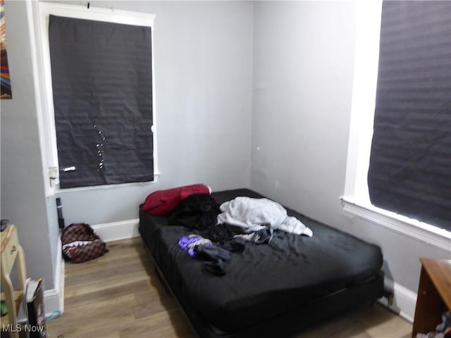 bedroom with wood finished floors and baseboards