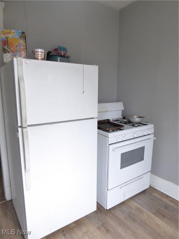 kitchen with white appliances and light wood-type flooring