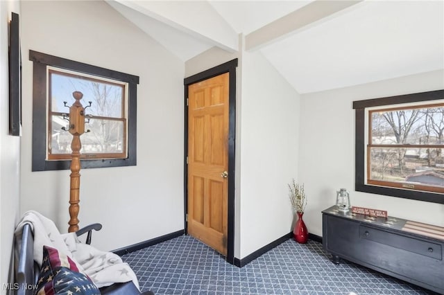 interior space featuring vaulted ceiling with beams, baseboards, and dark carpet