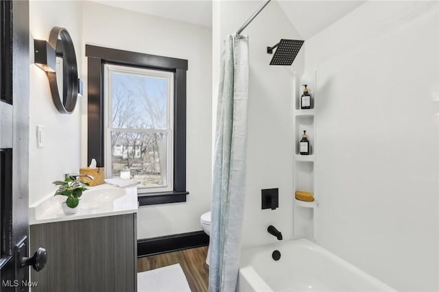 full bath featuring baseboards, toilet, shower / tub combo, wood finished floors, and vanity