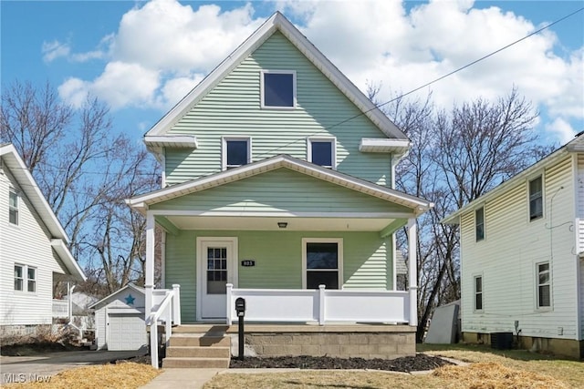 american foursquare style home featuring driveway, covered porch, an outdoor structure, a garage, and central air condition unit