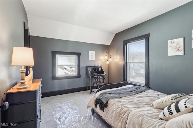 carpeted bedroom with baseboards and vaulted ceiling