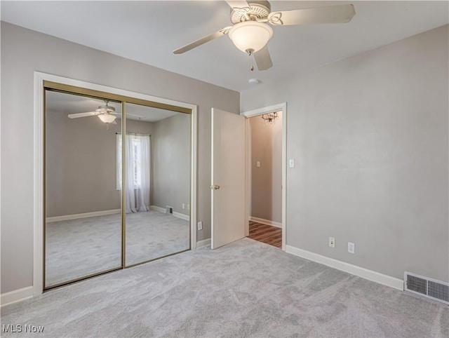 unfurnished bedroom featuring a closet, visible vents, carpet flooring, and baseboards