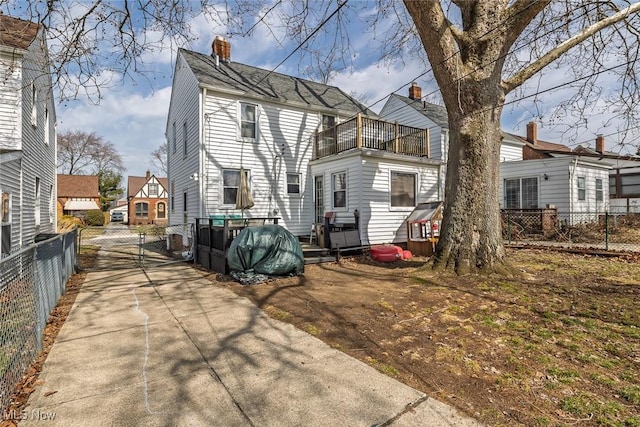 back of property with fence and a chimney