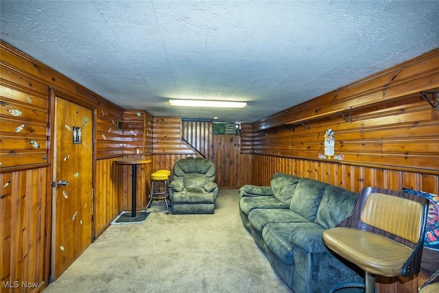 living area featuring wood walls, a textured ceiling, and carpet