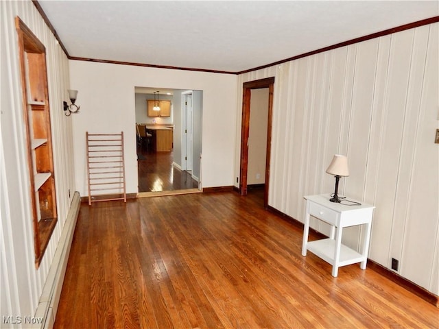 unfurnished bedroom featuring crown molding, wood finished floors, baseboards, and a baseboard radiator