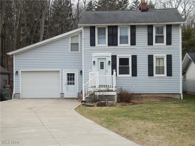 view of front of home featuring a front yard, roof with shingles, a chimney, a garage, and driveway