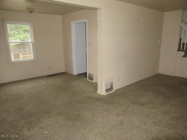 carpeted spare room featuring visible vents