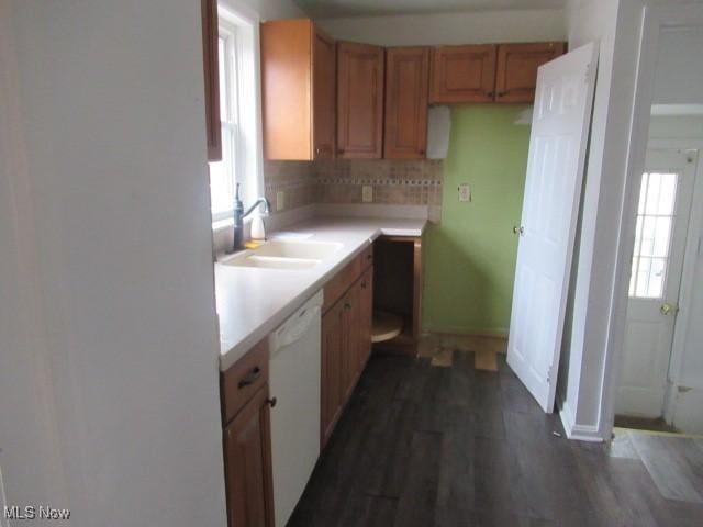 kitchen with a wealth of natural light, dishwasher, light countertops, and a sink