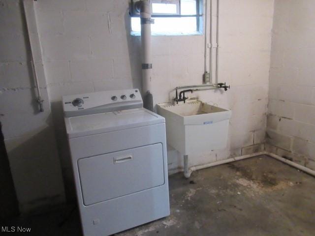 laundry area with laundry area, concrete block wall, washer / clothes dryer, and a sink