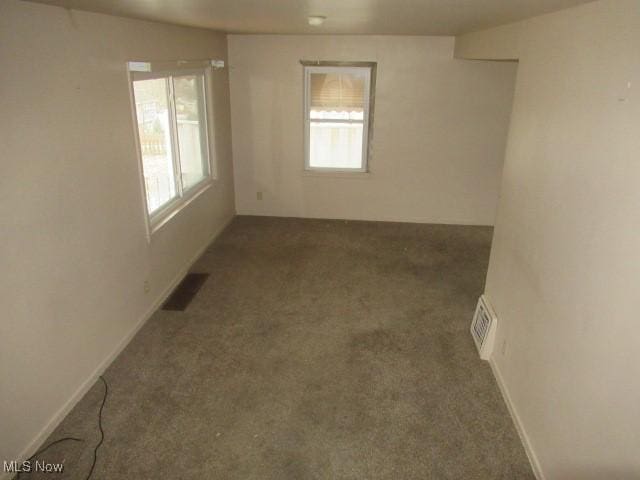 spare room featuring visible vents, baseboards, and carpet floors