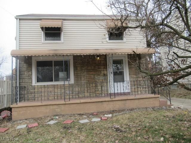 view of front of home with covered porch and fence