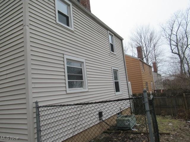 view of home's exterior with crawl space and fence