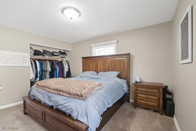 bedroom with light colored carpet, a closet, and baseboards