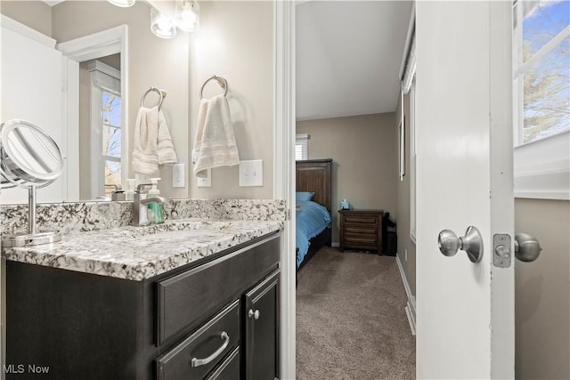 ensuite bathroom featuring baseboards, ensuite bath, and vanity