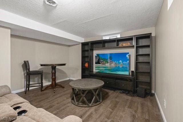 living area with a textured ceiling and wood finished floors