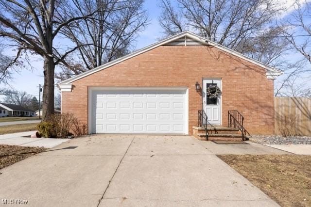 single story home featuring a garage, brick siding, and driveway