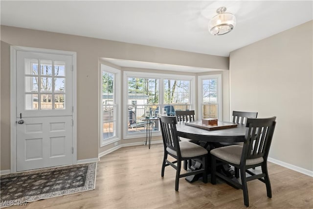 dining area with light wood finished floors and baseboards