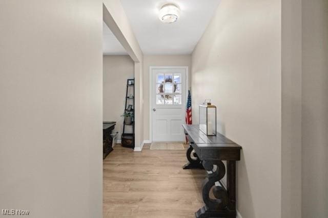 foyer entrance featuring light wood-type flooring and baseboards