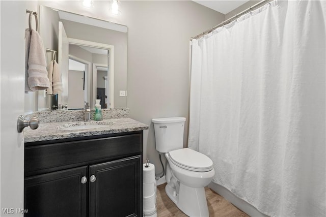 full bathroom featuring toilet, vanity, and wood finished floors