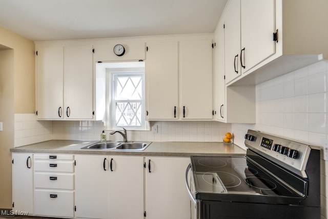 kitchen with white cabinets, stainless steel range with electric cooktop, and a sink