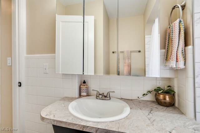 bathroom with vanity and tile walls