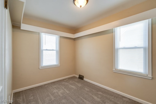 empty room featuring baseboards and carpet