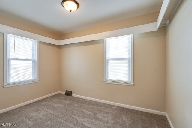 unfurnished room with baseboards, carpet floors, and plenty of natural light