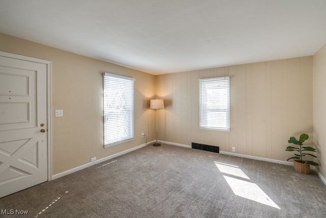 unfurnished room with baseboards, visible vents, and carpet floors