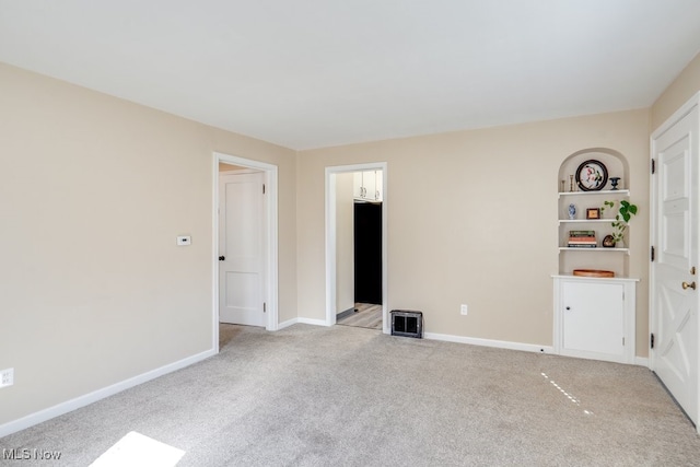 empty room with light colored carpet and baseboards