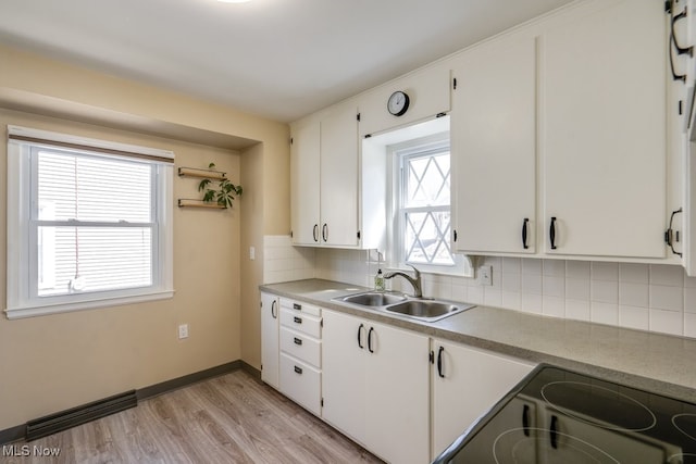 kitchen featuring white cabinetry, electric range, tasteful backsplash, and a sink